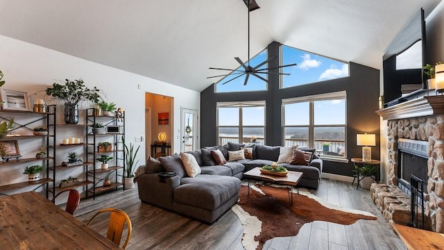 living room with hardwood / wood-style floors, a fireplace, high vaulted ceiling, and ceiling fan