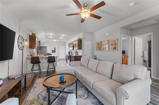 living room with lofted ceiling, hardwood / wood-style floors, and ceiling fan