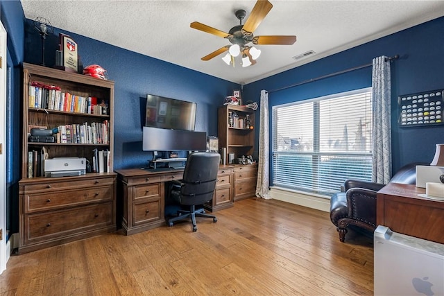 office space with a textured ceiling, ceiling fan, and light wood-type flooring