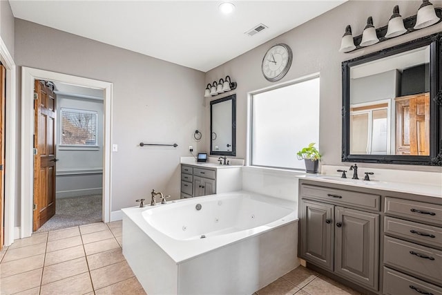 bathroom featuring tile patterned floors, vanity, and a tub