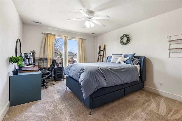 carpeted bedroom featuring ceiling fan and a textured ceiling