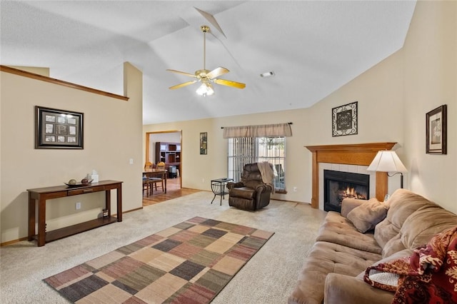 living room featuring a tiled fireplace, ceiling fan, light colored carpet, and high vaulted ceiling