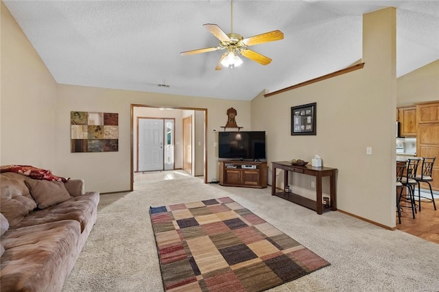 carpeted living room featuring ceiling fan, lofted ceiling, and a textured ceiling