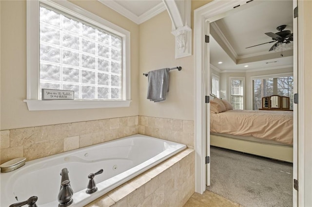 bathroom with ceiling fan, tile patterned flooring, a relaxing tiled tub, ornamental molding, and a raised ceiling