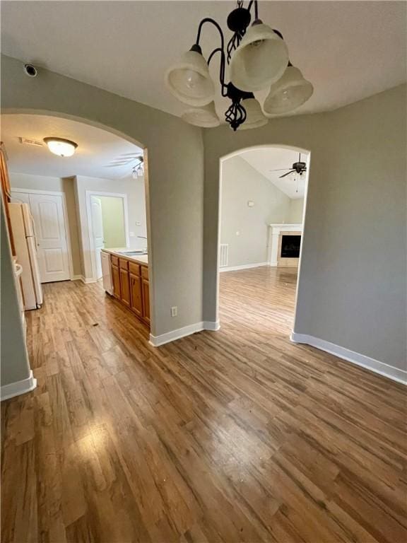 unfurnished dining area with sink, ceiling fan, and light hardwood / wood-style flooring