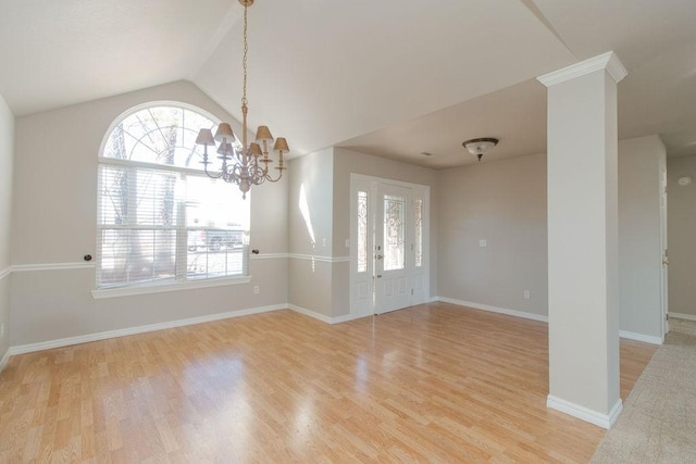 spare room with lofted ceiling, plenty of natural light, and light hardwood / wood-style flooring