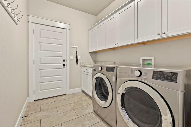 laundry room featuring washer and clothes dryer and cabinets