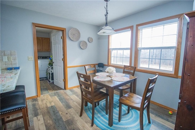 dining space with washer / dryer and light hardwood / wood-style floors