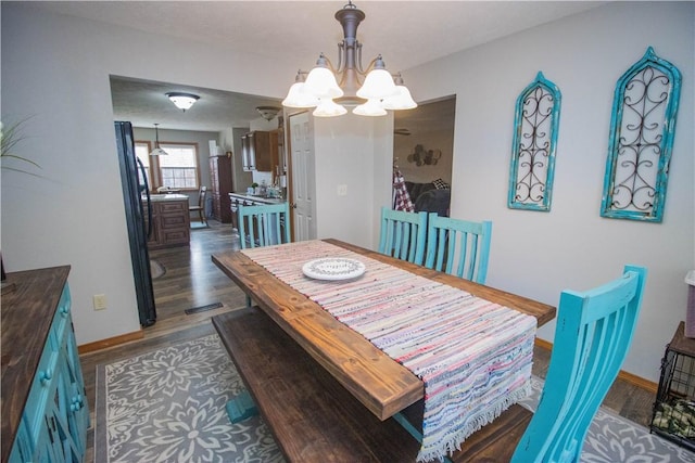 dining room with a notable chandelier and dark hardwood / wood-style floors