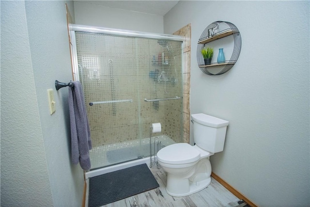 bathroom with a shower with door, wood-type flooring, and toilet