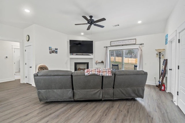 living room featuring hardwood / wood-style flooring, ceiling fan, and lofted ceiling