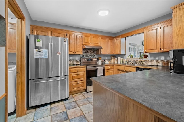 kitchen featuring appliances with stainless steel finishes, washer / clothes dryer, sink, and backsplash