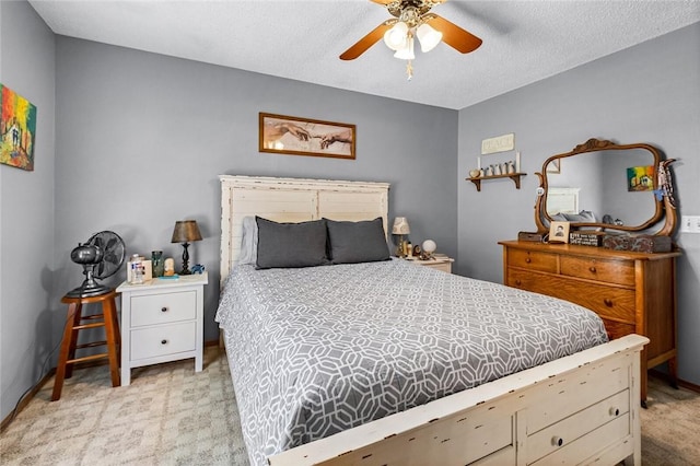 bedroom featuring light carpet, a textured ceiling, and ceiling fan