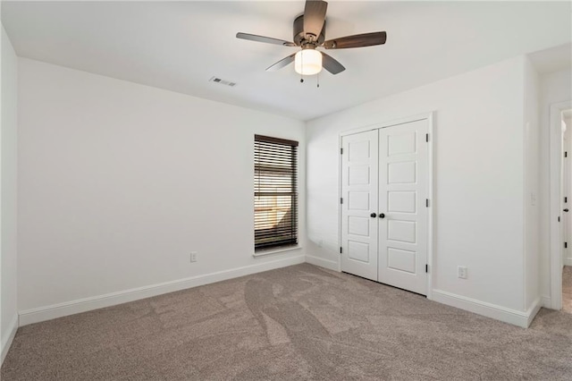 unfurnished bedroom featuring light carpet, a closet, and ceiling fan