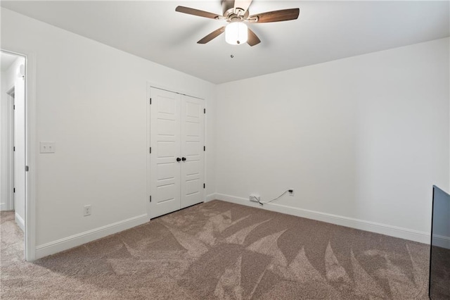 unfurnished bedroom with ceiling fan, a closet, and carpet