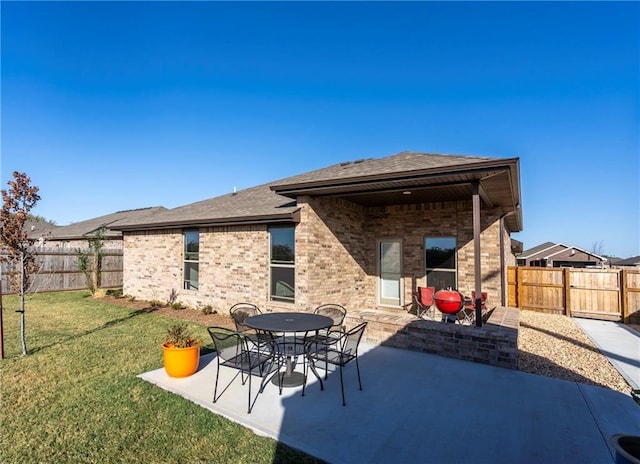 back of house with a yard and a patio