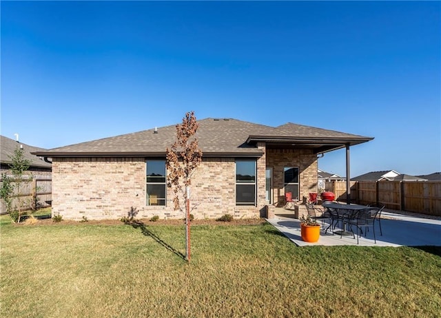 rear view of property featuring a patio area and a lawn