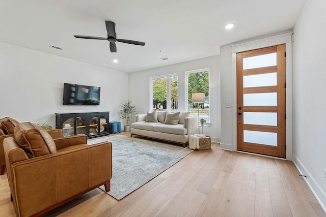 living room featuring ceiling fan and light wood-type flooring