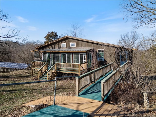 rear view of property with a wooden deck and a sunroom