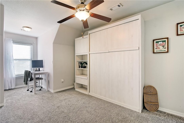 carpeted office space featuring ceiling fan