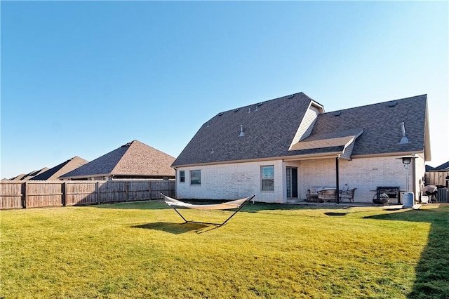 rear view of house featuring a patio area, a lawn, and an outdoor fire pit