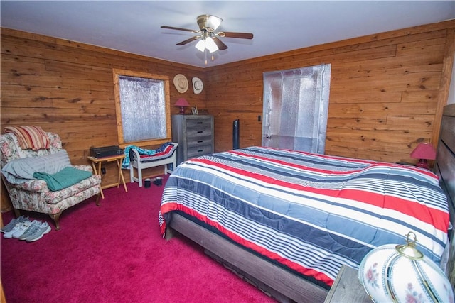 carpeted bedroom featuring ceiling fan and wooden walls