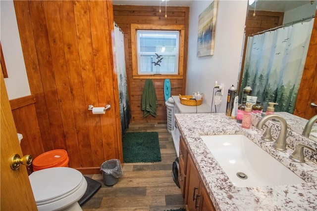 bathroom with vanity, hardwood / wood-style flooring, toilet, and wood walls