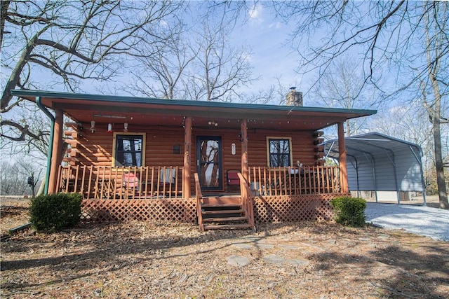 log-style house with a porch and a carport