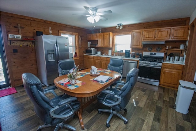 office space with ceiling fan, wooden walls, and dark hardwood / wood-style flooring