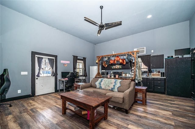 living room featuring ceiling fan, dark hardwood / wood-style floors, and a towering ceiling