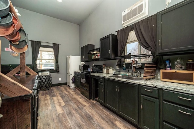 kitchen with dark hardwood / wood-style floors, black electric range, light stone countertops, an AC wall unit, and white fridge