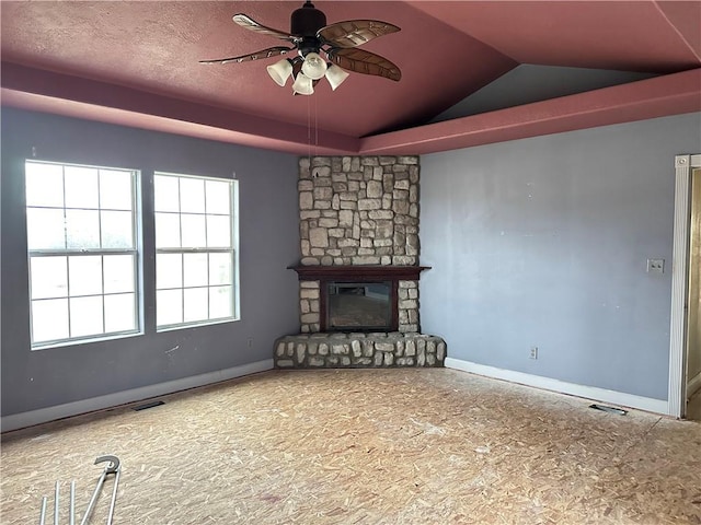 unfurnished living room featuring ceiling fan, lofted ceiling, and a fireplace