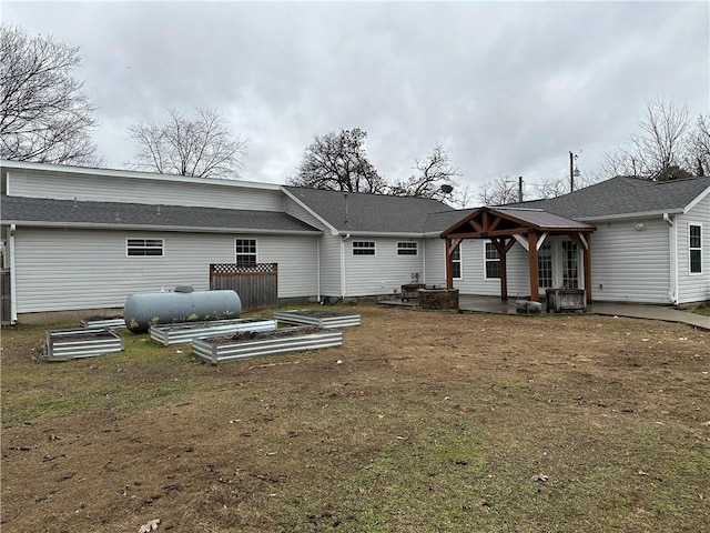 back of house with a gazebo and a lawn