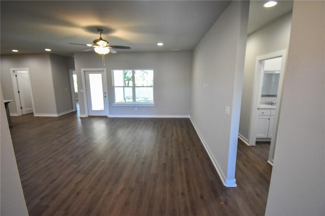 unfurnished living room with dark wood-type flooring and ceiling fan