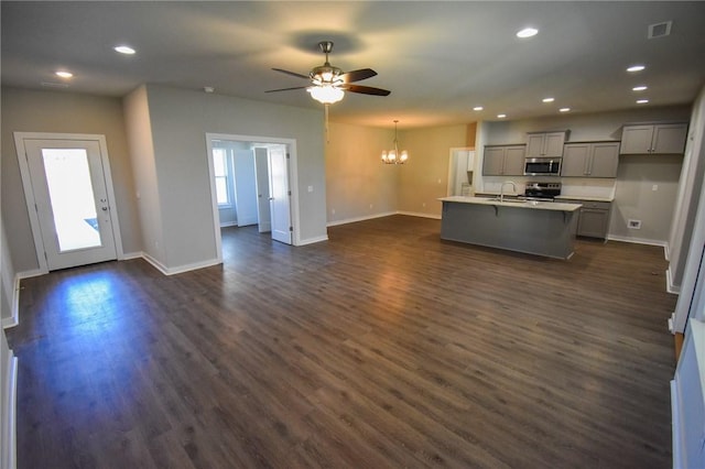 kitchen with gray cabinets, dark hardwood / wood-style floors, an island with sink, sink, and stainless steel appliances