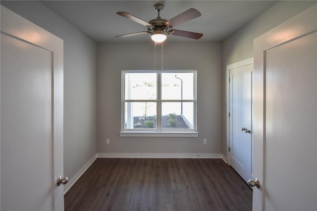 spare room featuring dark wood-type flooring and ceiling fan