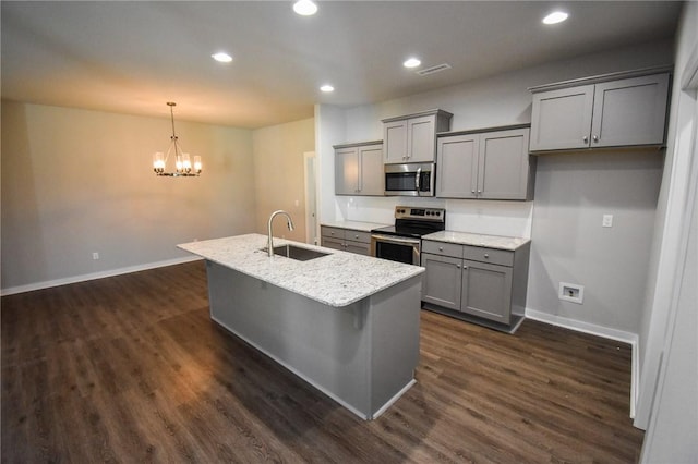 kitchen featuring gray cabinets, sink, hanging light fixtures, stainless steel appliances, and a center island with sink