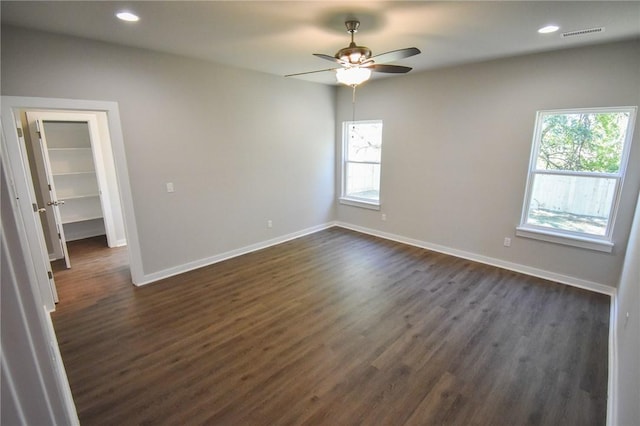 empty room with dark hardwood / wood-style floors and ceiling fan