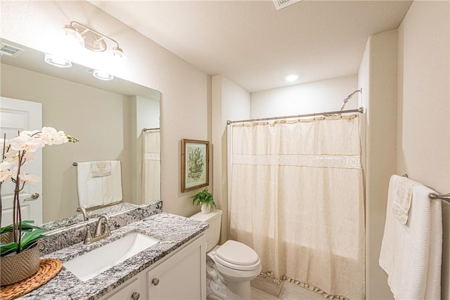 bathroom featuring a shower with curtain, vanity, and toilet