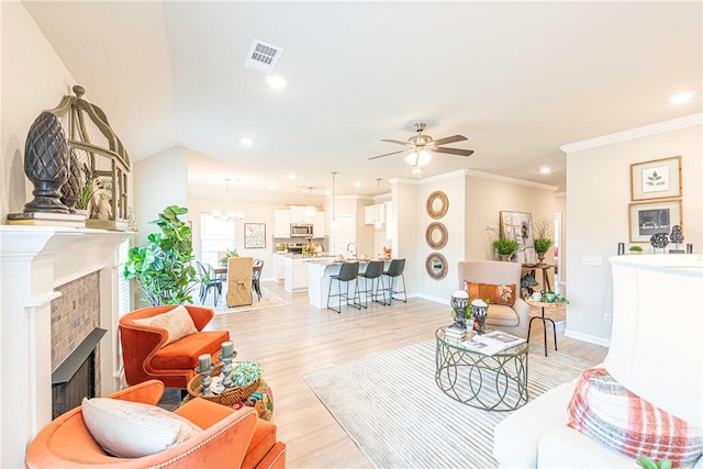 living room featuring ceiling fan, ornamental molding, lofted ceiling, and light wood-type flooring