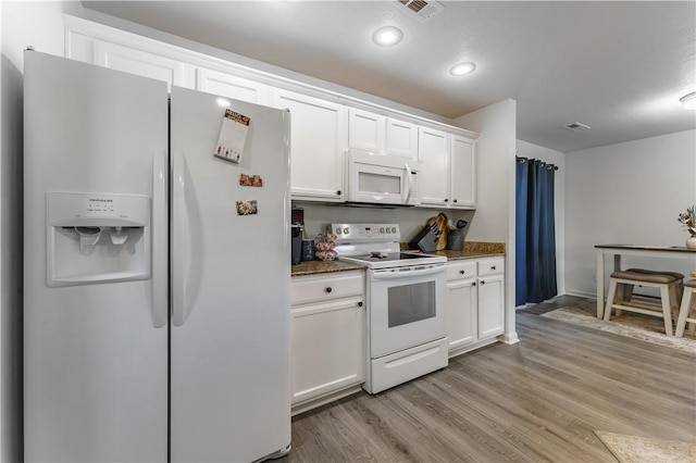 kitchen featuring light wood-type flooring, white cabinets, white appliances, and dark stone counters