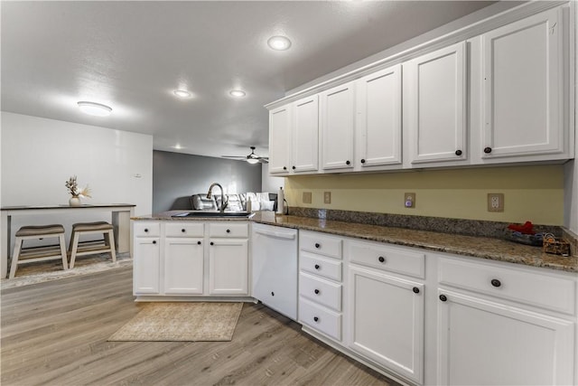 kitchen featuring sink, white cabinets, white dishwasher, and light wood-type flooring