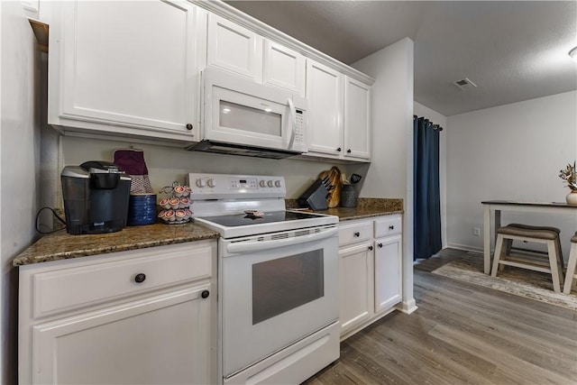 kitchen featuring white cabinetry, white appliances, dark stone counters, and hardwood / wood-style floors