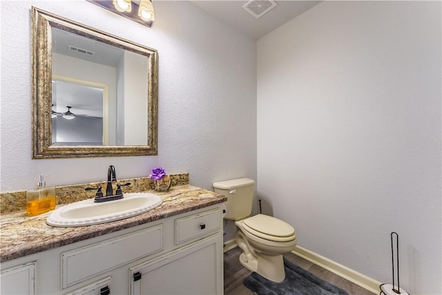 bathroom with hardwood / wood-style flooring, vanity, and toilet