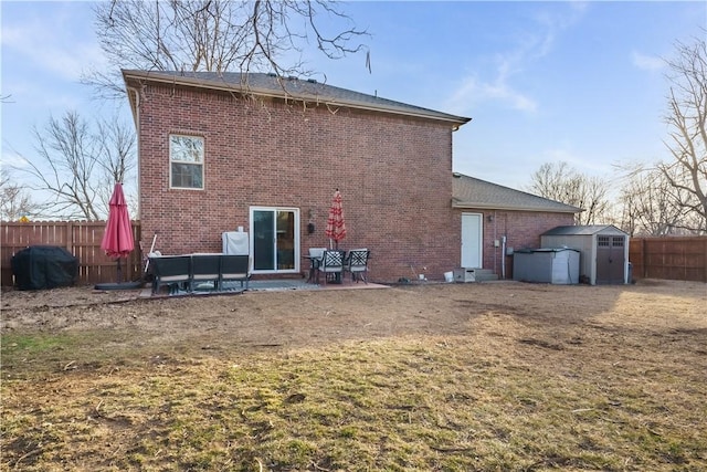 rear view of property with a patio area, a shed, and a lawn