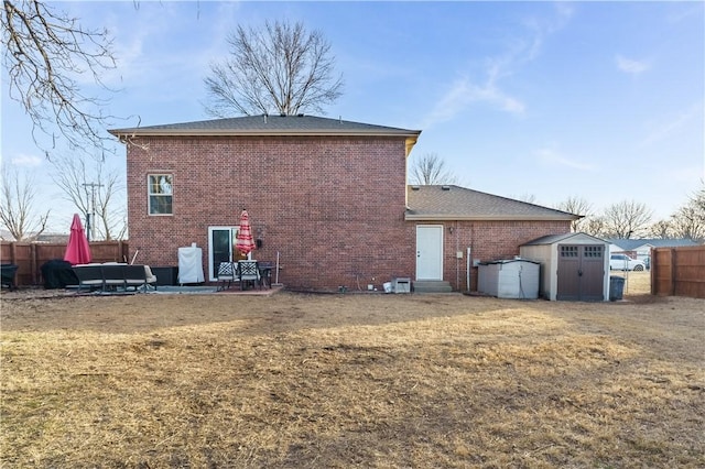 back of property with a patio, a lawn, and a storage unit