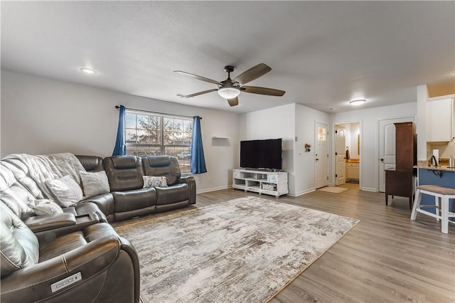 living room featuring ceiling fan and light wood-type flooring