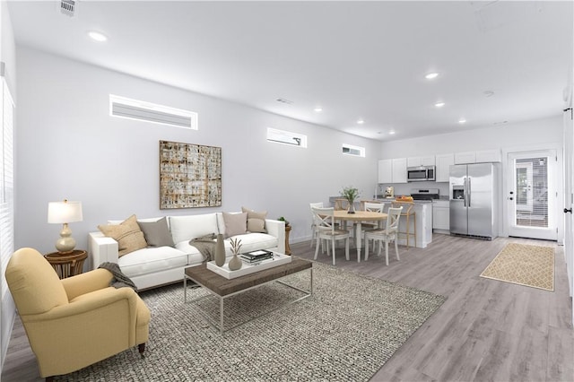 living room with a healthy amount of sunlight and light hardwood / wood-style floors