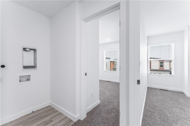 hallway with light colored carpet and a wealth of natural light