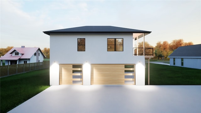 view of front of house featuring a yard, a garage, and a balcony